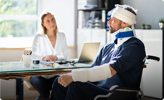 Injured man in a wheelchair discussing a personal injury case with a lawyer